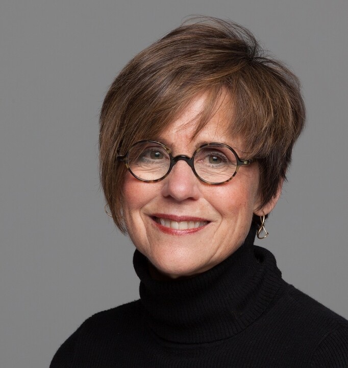 Headshot of Lifetime Arts Trainer, Lynda Monick-Isenberg. She has short brown hair, glasses, and is smiling.